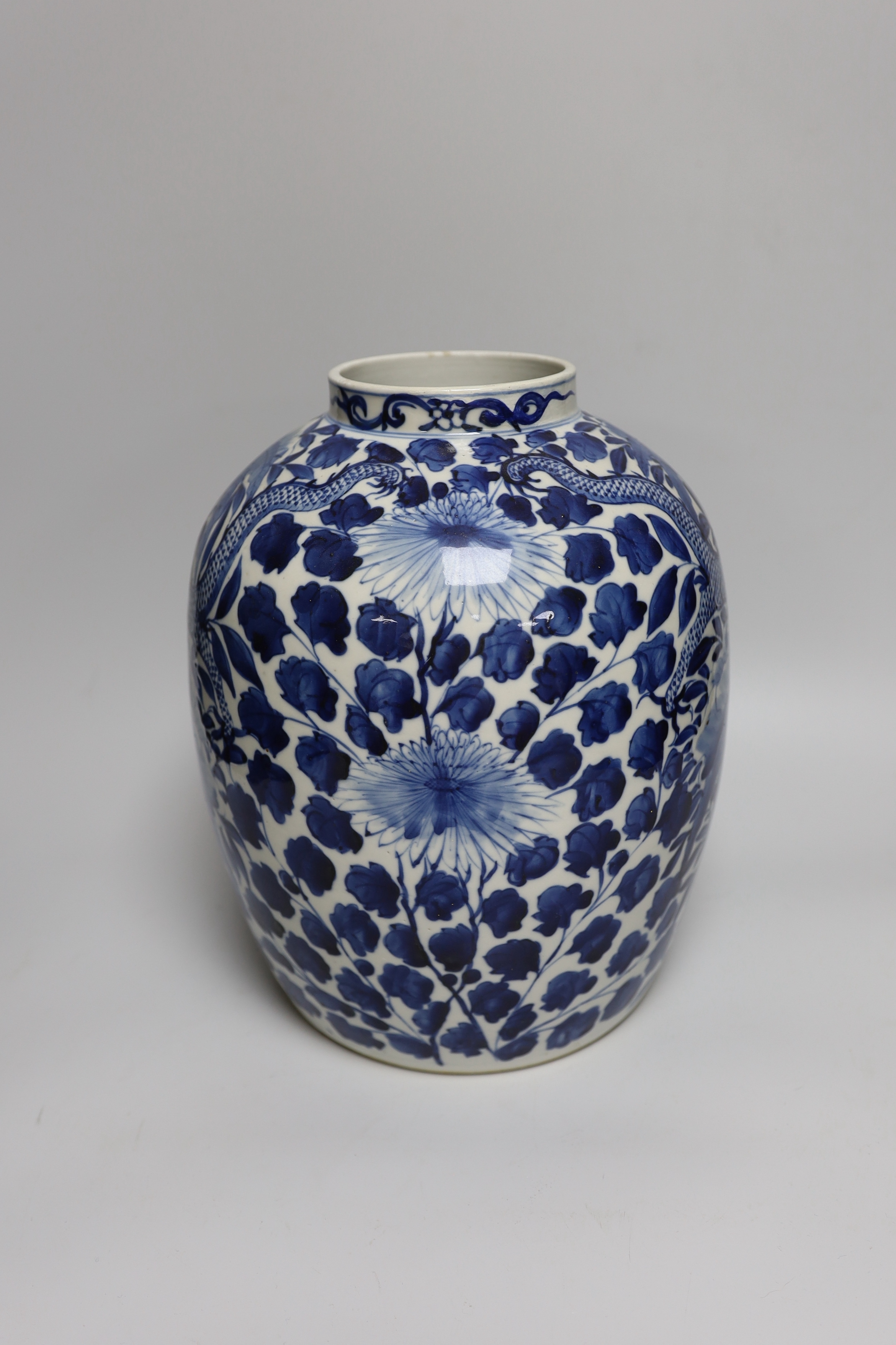 A large Chinese blue and white jar painted with a dragon amongst leaves and flowers, 29cm high